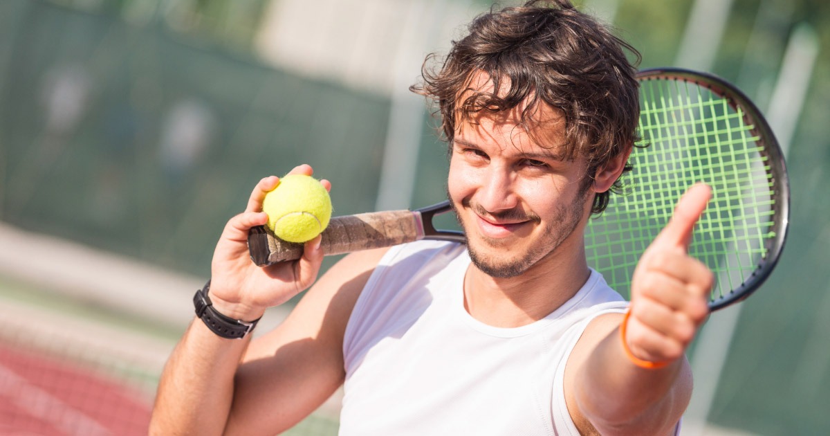 Tennis player giving thumbs up during practice session