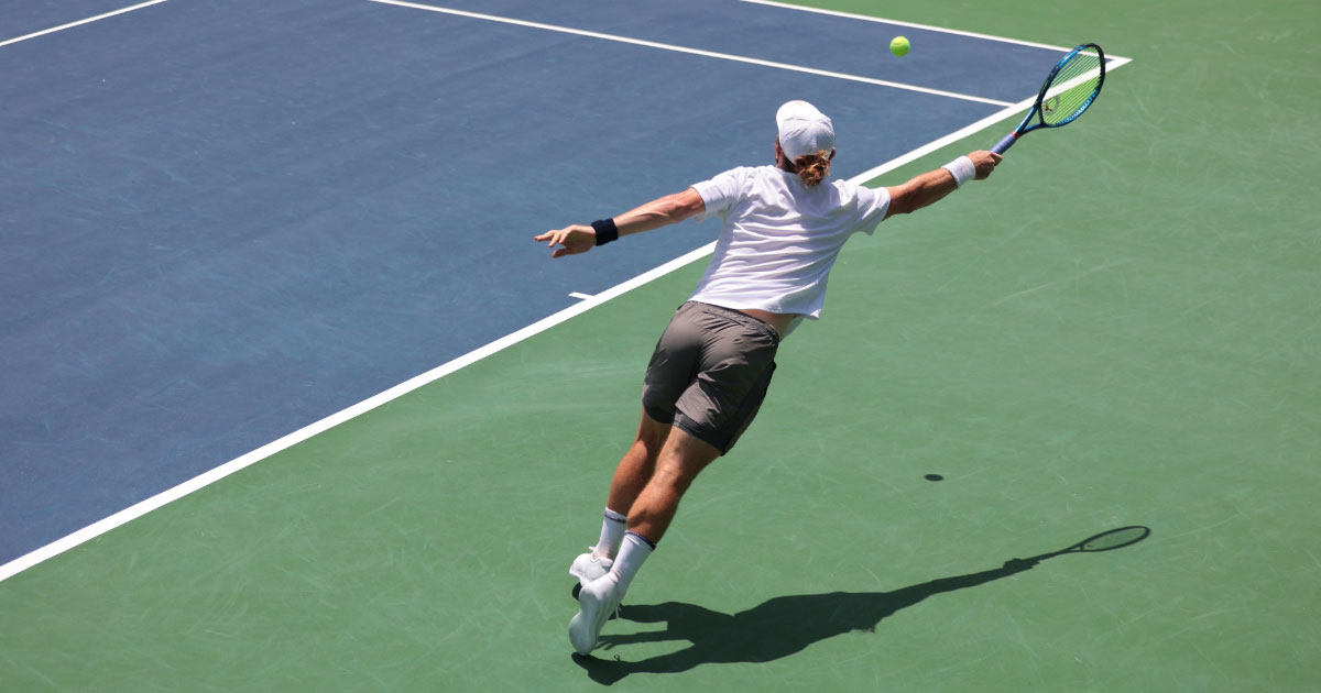 Young male player stretching out to reach a passing shot his opponent hit